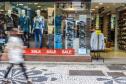 Pedestre em frente a uma vitrine.